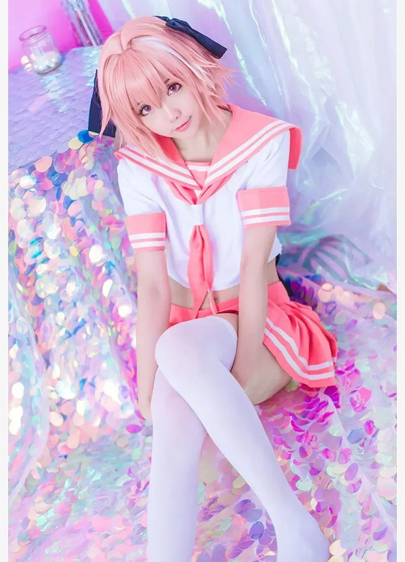 Femboy in a Pink Astolfo Cosplay Outfit costume sitting on a colorful, glittery surface