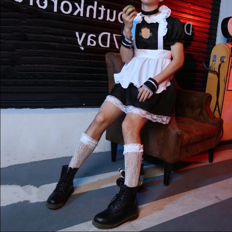 Femboy in a maid costume sitting on a chair with a dark background featuring text.